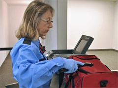 Security Personnel Uses ETD Equipment on Passenger Luggage