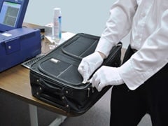 Security Screener Performing an ETD Test on Baggage